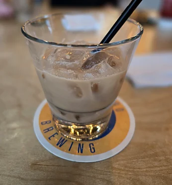 Iced cream cocktail with a straw on a bar coaster