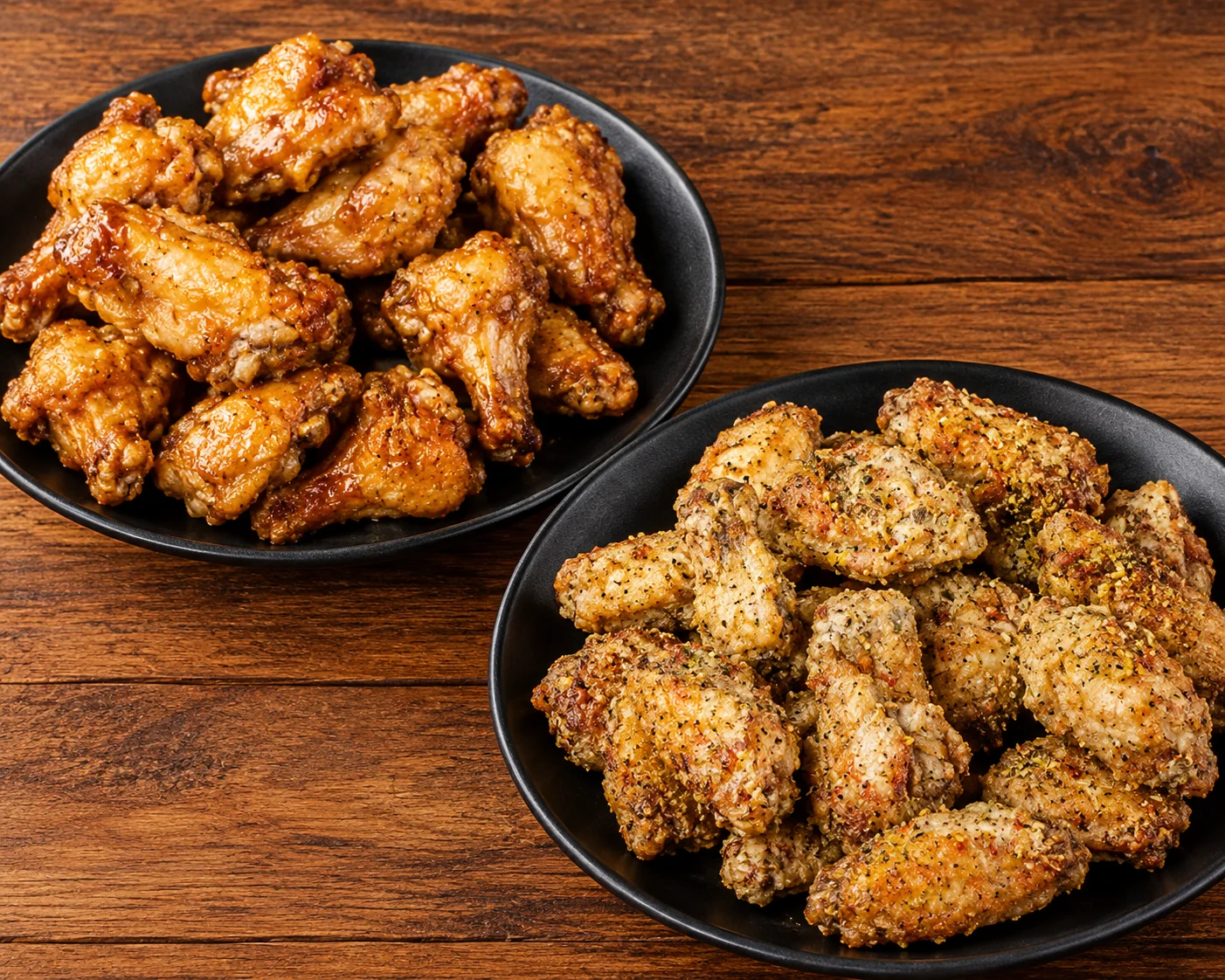 Two baskets of crispy chicken wings, plain and dry rub