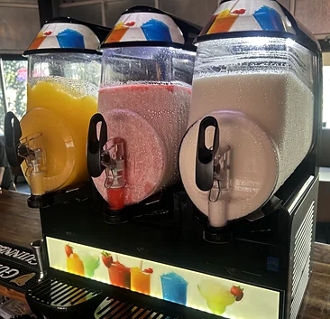 Three frozen slush drink machines on the bar