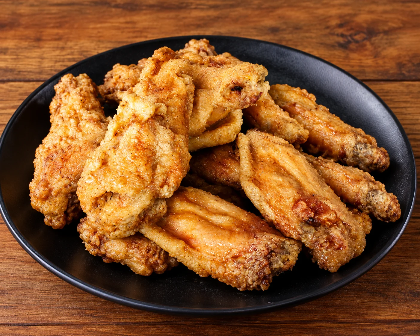 Crispy chicken wings in a newspaper-lined basket